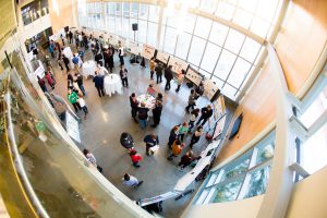 An overhead, fish-eye view of the poster session at a DENIN Graduate Research Symposium