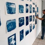 man standing in front of a wall of photographs